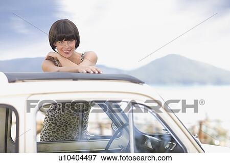 Stock Photo - Woman in a tiny car. Fotosearch