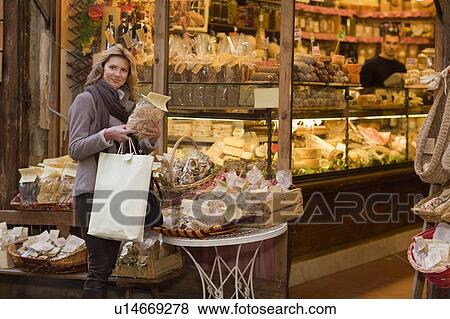 Stock Photo - Woman in front of deli. Fotosearch