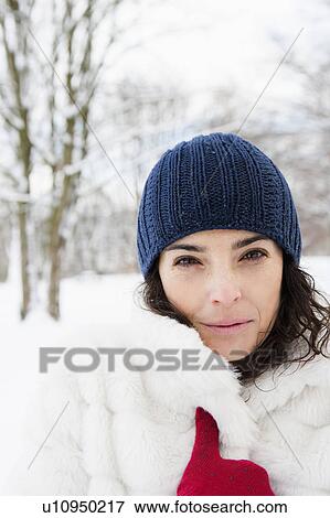 Stock Photo - Woman in snowy woods looking to camera. Fotosearch