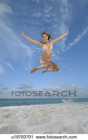 Woman jumping on beach View Large Photo Image Stock Image - Woman jumping on beach. Fotosearch