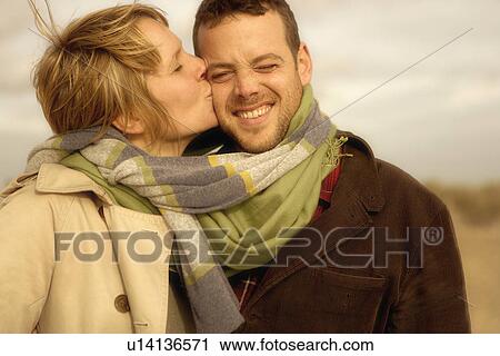 Woman kissing man on beach scarves mixed View Large Photo Image Stock Image - Woman kissing man on beach scarves mixed. Fotosearch