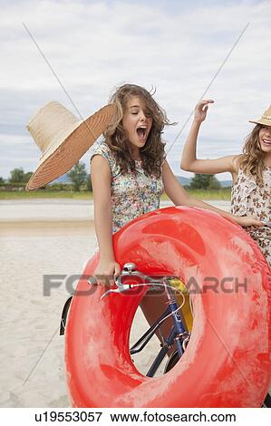 Woman knocks hat off her friends head View Large Photo Image Stock Photo - Woman knocks hat off her friends head. Fotosearch
