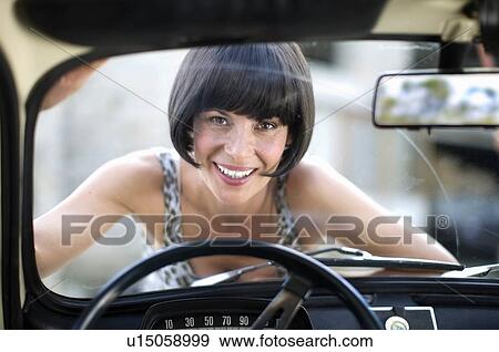 Woman laying on the front of a car View Large Photo Image Stock Photo - Woman laying on the front of a car. Fotosearch