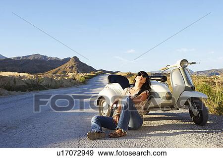 Stock Photo - Woman leaning on motorbike and sidecar. Fotosearch