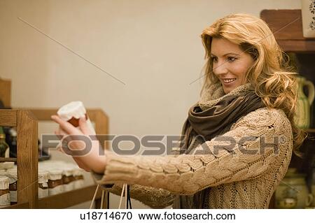 Stock Image - Woman looking around shop. Fotosearch