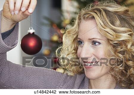 Woman looking at christmas ball View Large Photo Image Stock Image - Woman looking at christmas ball. Fotosearch