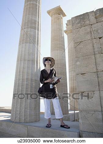 Stock Image - Woman looking at historical ruins. Fotosearch