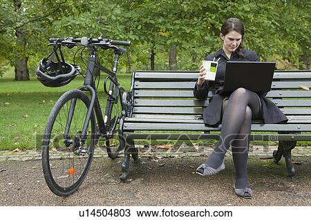 Woman looking at laptop and eating lunch View Large Photo Image Stock Image - Woman looking at laptop and eating lunch. Fotosearch