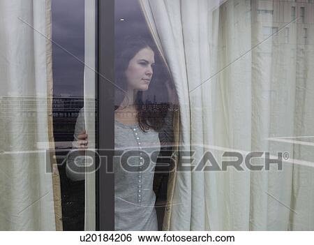 Stock Photograph - Woman looking out of window. Fotosearch
