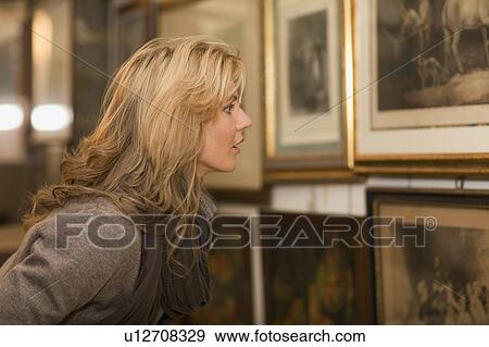 Woman looking up to painting View Large Photo Image Stock Photo - Woman looking up to painting. Fotosearch