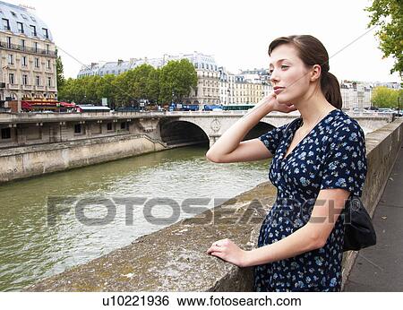 Woman looks over river seine in Paris View Large Photo Image Stock Photograph - Woman looks over river seine in Paris. Fotosearch