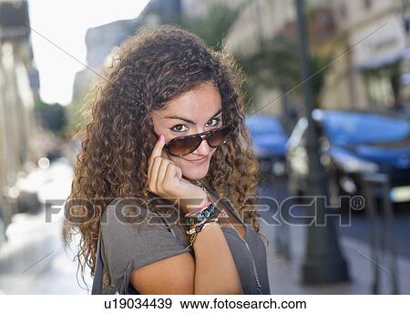 Woman looks over sunglasses portrait View Large Photo Image Stock Photo - Woman looks over sunglasses portrait. Fotosearch