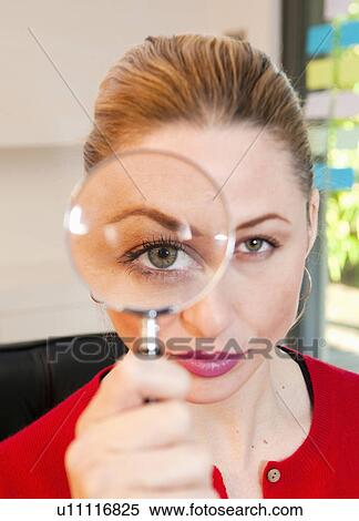 Stock Photography - Woman looks thru magnifying glass. Fotosearch