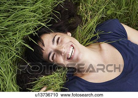 Stock Image - Woman lying in grass. Fotosearch