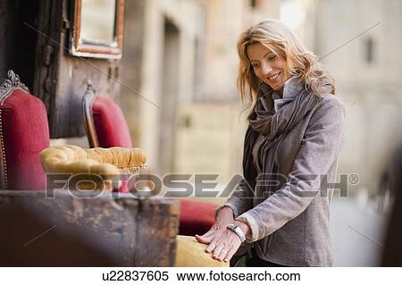 Stock Photography - Woman marveling at antique furniture. Fotosearch