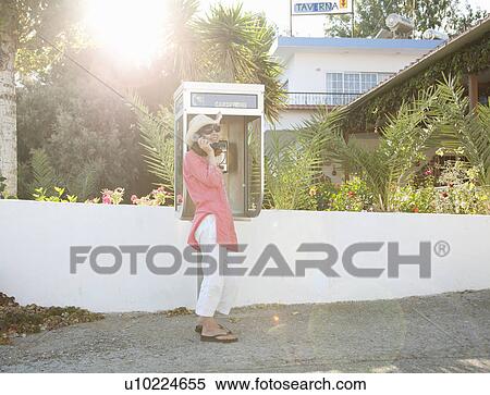 Stock Photography - Woman on payphone in street. Fotosearch