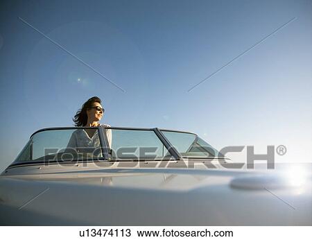 Stock Image - Woman on speedboat. Fotosearch