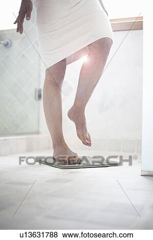 Woman on weighing scales View Large Photo Image Stock Photo - Woman on weighing scales. Fotosearch
