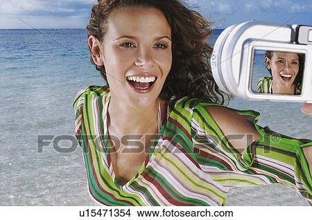 Woman photographing herself on beach View Large Photo Image Picture - Woman photographing herself on beach. Fotosearch