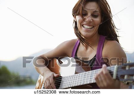Stock Photo - Woman playing guitar. Fotosearch