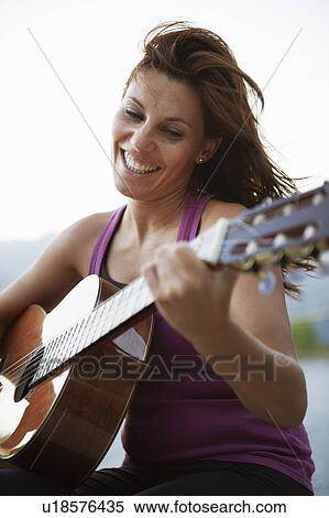 Stock Photography - Woman playing guitar. Fotosearch