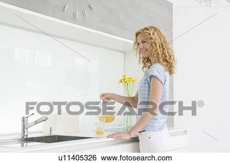 Stock Photograph - Woman pouring orange juice. Fotosearch