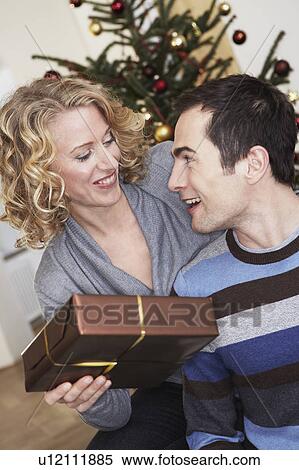 Stock Photography - Woman presenting man a gift. Fotosearch
