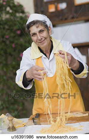Woman producing pasta View Large Photo Image Stock Photograph - Woman producing pasta. Fotosearch