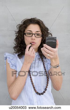 Woman putting lipstick on View Large Photo Image Stock Image - Woman putting lipstick on. Fotosearch