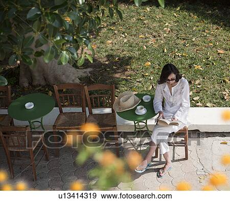 Woman reading at cafe table View Large Photo Image Stock Photo - Woman reading at cafe table. Fotosearch