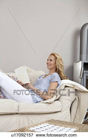 Stock Photo - Woman reading on couch. Fotosearch