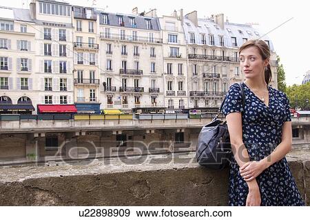 Woman relaxes by river seine in Paris View Large Photo Image Stock Photo - Woman relaxes by river seine in Paris. Fotosearch