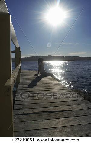 Woman relaxing by boat house View Large Photo Image Stock Image - Woman relaxing by boat house. Fotosearch