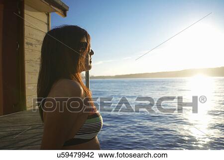 Woman relaxing by boat house View Large Photo Image Stock Image - Woman relaxing by boat house. Fotosearch