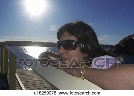 Woman relaxing by boat house View Large Photo Image Stock Photo - Woman relaxing by boat house. Fotosearch
