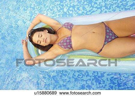 Woman relaxing on lilo in swimming pool View Large Photo Image Stock Photo - Woman relaxing on lilo in swimming pool. Fotosearch