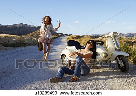 Woman resting by road with motorbike View Large Photo Image Stock Photo - Woman resting by road with motorbike. Fotosearch