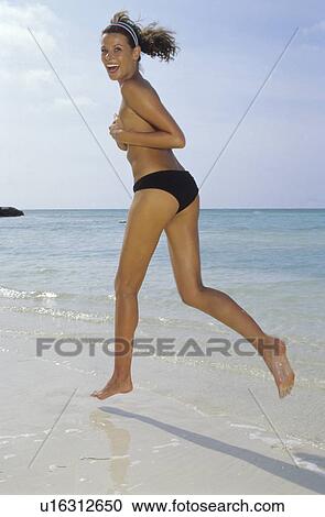 Woman running on beach View Large Photo Image Stock Image - Woman running on beach. Fotosearch