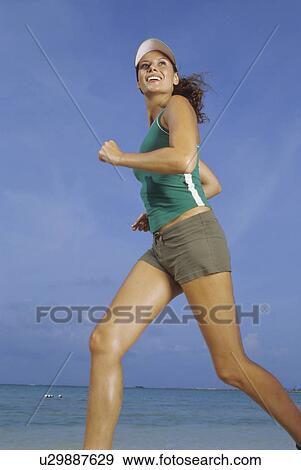 Stock Photo - Woman running on beach. Fotosearch