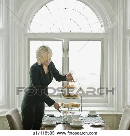 Stock Image - Woman setting up table. Fotosearch