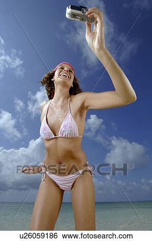 Woman shooting herself on beach View Large Photo Image Stock Photograph - Woman shooting herself on beach. Fotosearch