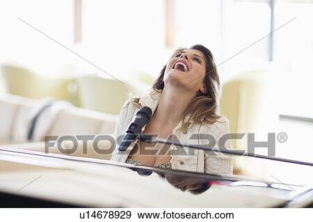Woman singing and playing piano View Large Photo Image Stock Photo - Woman singing and playing piano. Fotosearch