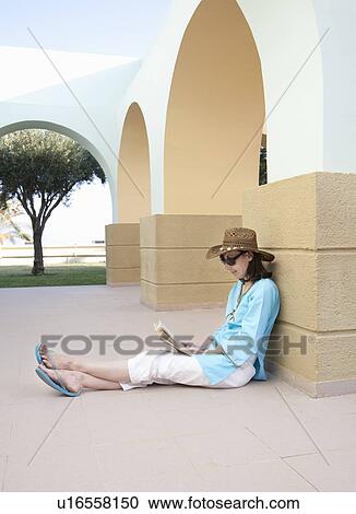 Stock Image - Woman sitting and reading. Fotosearch