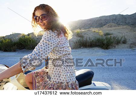 Woman sitting on a motorbike View Large Photo Image Stock Image - Woman sitting on a motorbike. Fotosearch