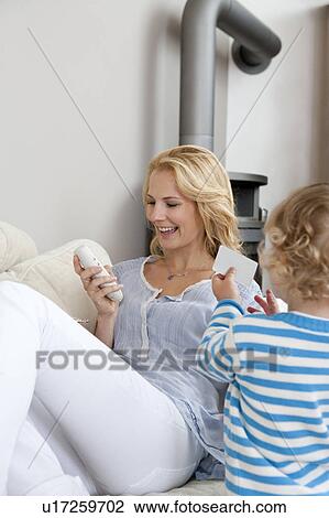 Woman sitting on couch View Large Photo Image Stock Image - Woman sitting on couch. Fotosearch