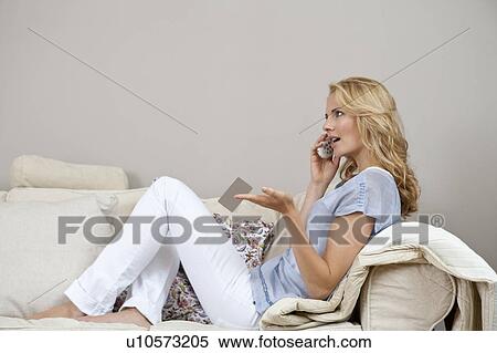 Woman sitting on couch View Large Photo Image Stock Photography - Woman sitting on couch. Fotosearch