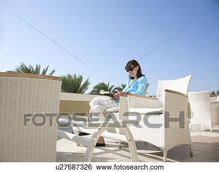 Woman sitting reading in sunshine View Large Photo Image Stock Photograph - Woman sitting reading in sunshine. Fotosearch