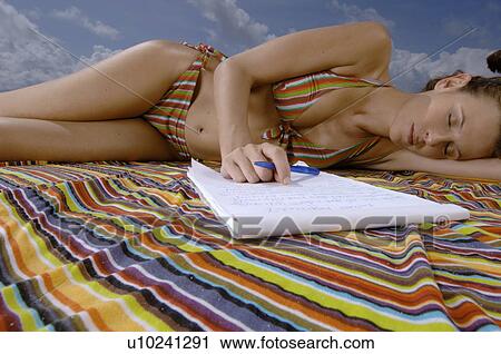 Stock Image - Woman sleeping on beach. Fotosearch