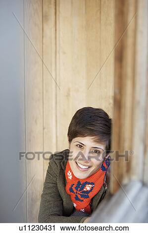 Stock Image - Woman smiling in a hut in a park. Fotosearch