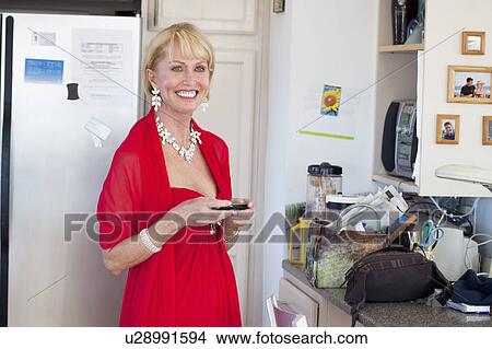 Woman smiling in kitchen View Large Photo Image Picture - Woman smiling in kitchen. Fotosearch
